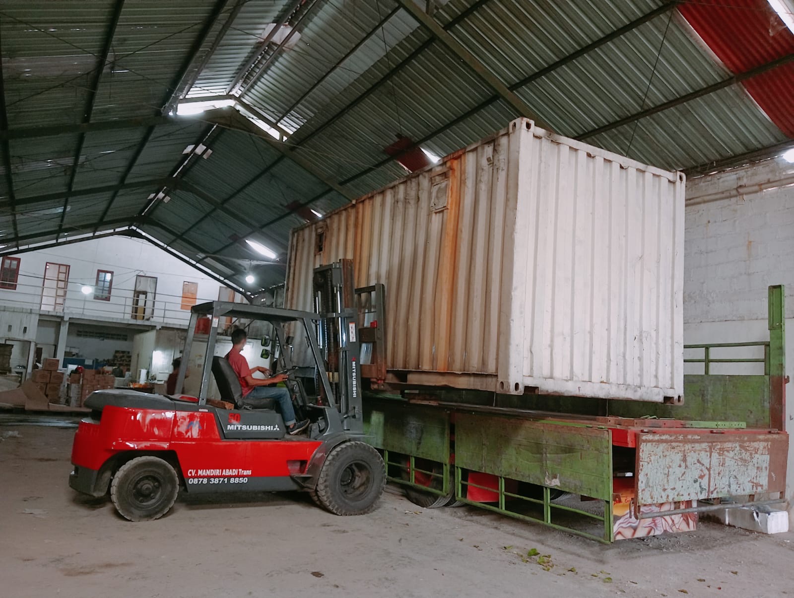 Forklift menangani kontainer di area gudang